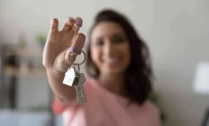 Mujer recibiendo las llaves de su apartamento VIS que es vivienda de interés social